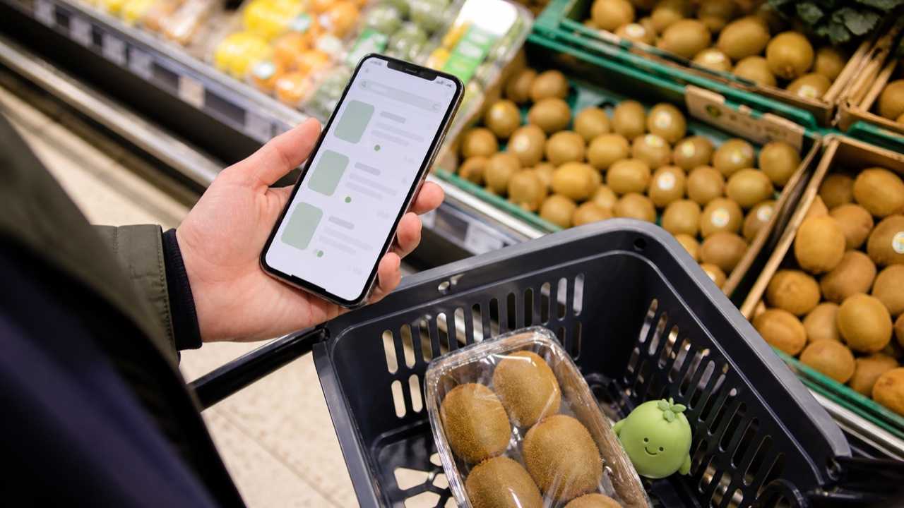 スーパーの在庫をスマホで確認する買い物客のイメージ