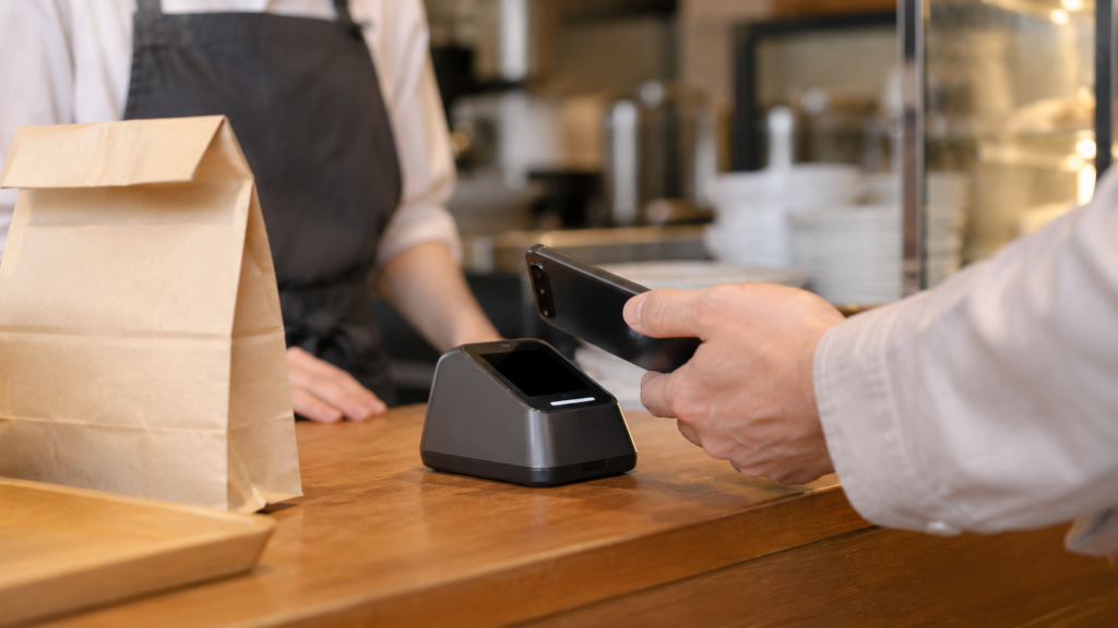 店頭の会計前にスマートフォンを読み取り端末へかざすイメージ