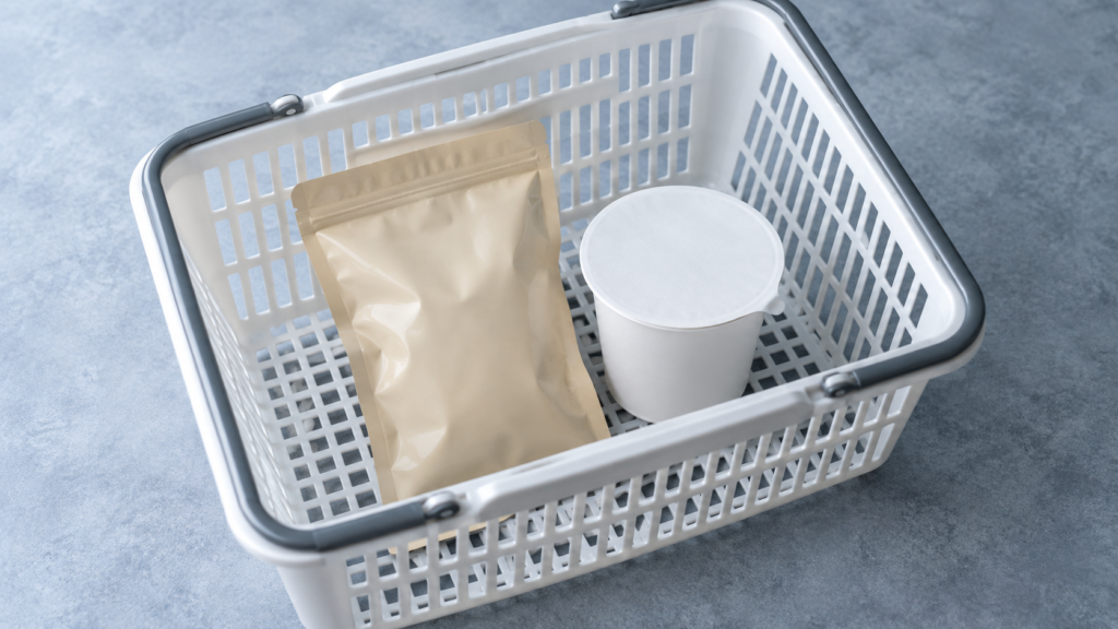 無地の食品袋とカップ容器を少量だけ入れた買い物カゴの俯瞰