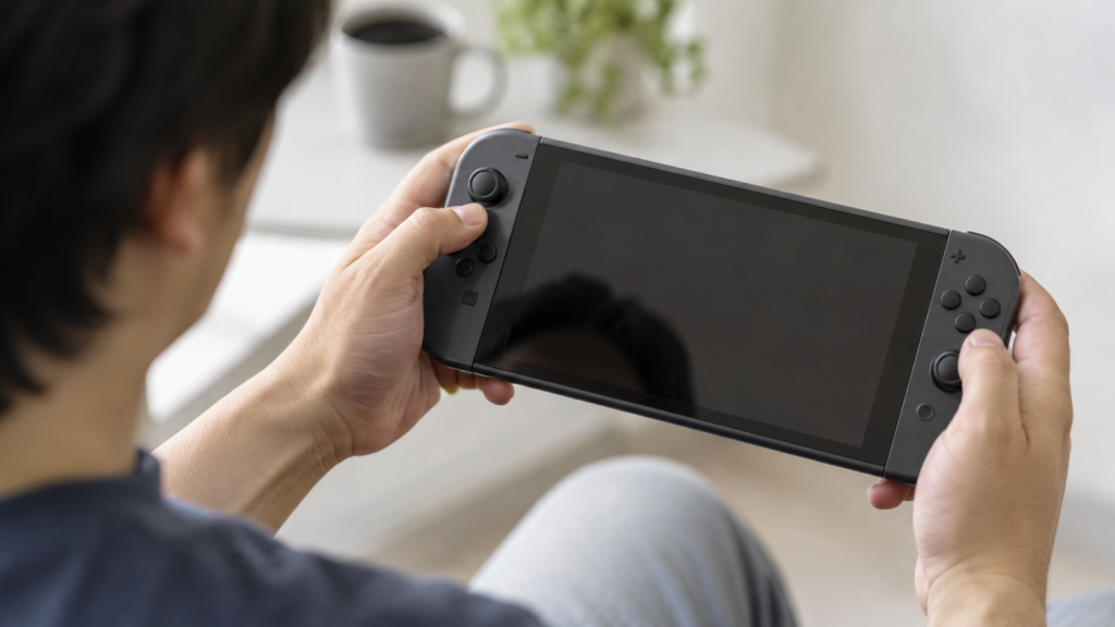 携帯ゲーム機を両手で少し傾けて操作するイメージ