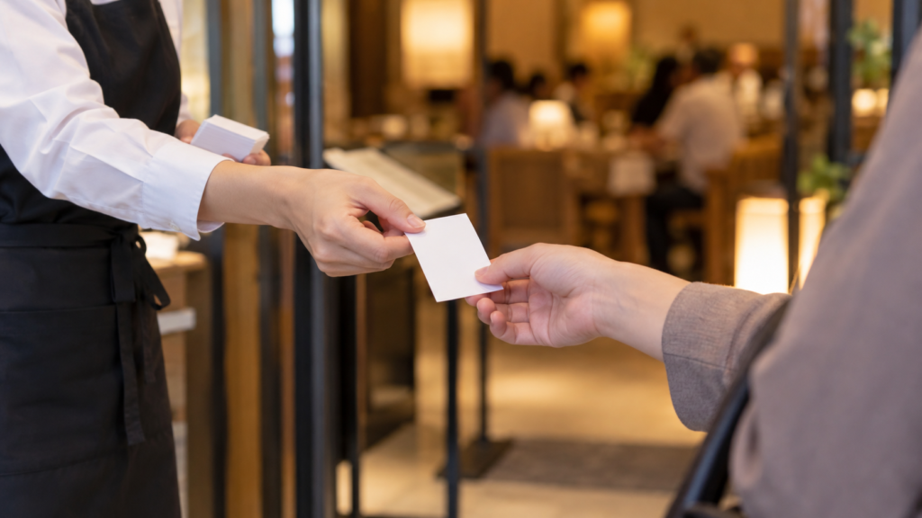 レストラン入口で整理券を受け取る手元のイメージ