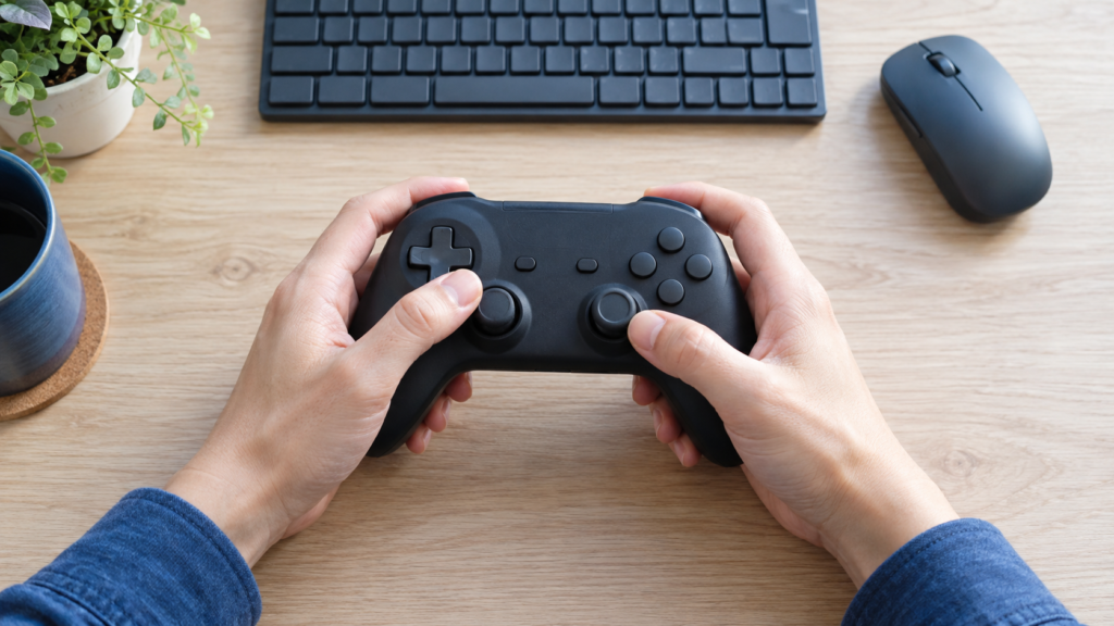 キーボードの前でゲームパッドを操作する手元のイメージ