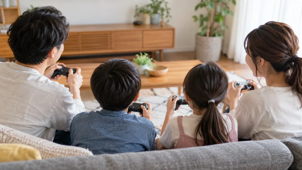 テレビの前で4人分のゲームの準備をする家族のイメージ